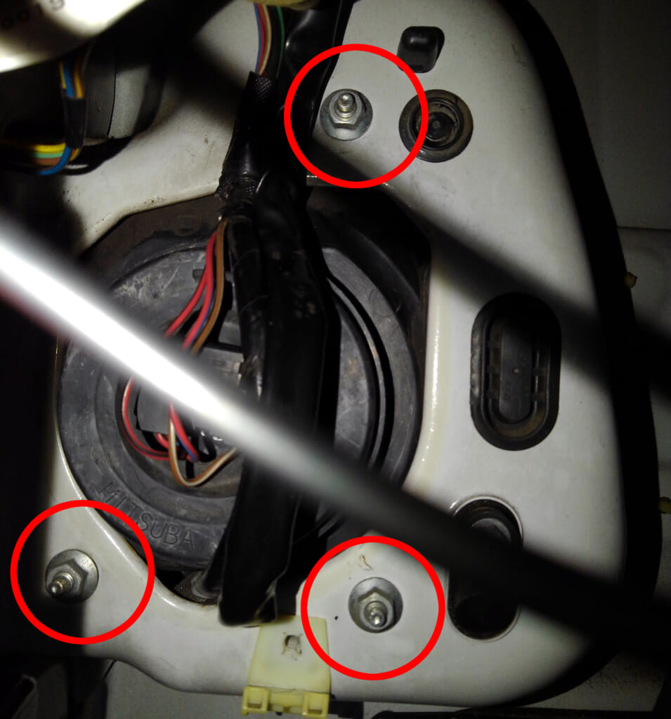 サンバートラックのヘッドライトを外す。赤丸の3箇所のボルトを外す。